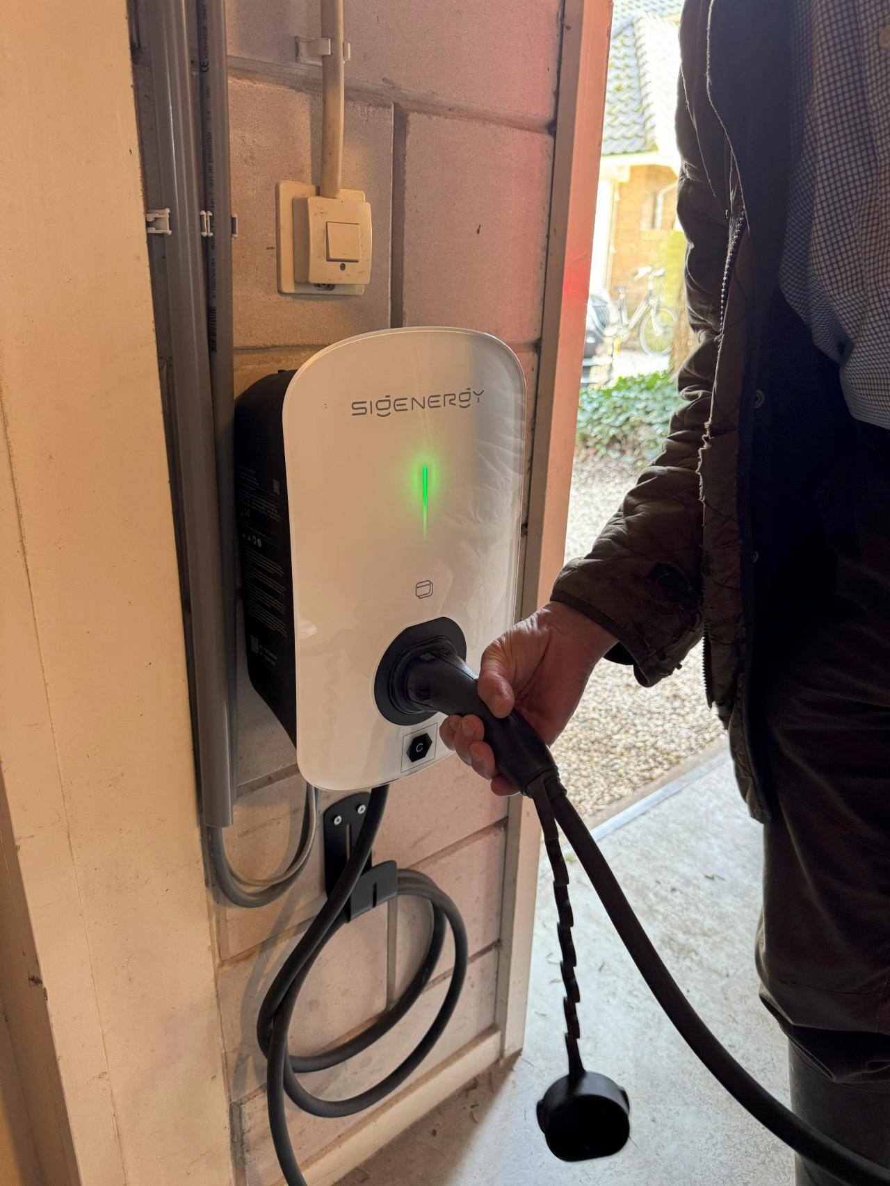 Tevreden klant Beter Duurzaam doet stekker in laadpaal Sigenergy nadat hij auto heeft opgeladen